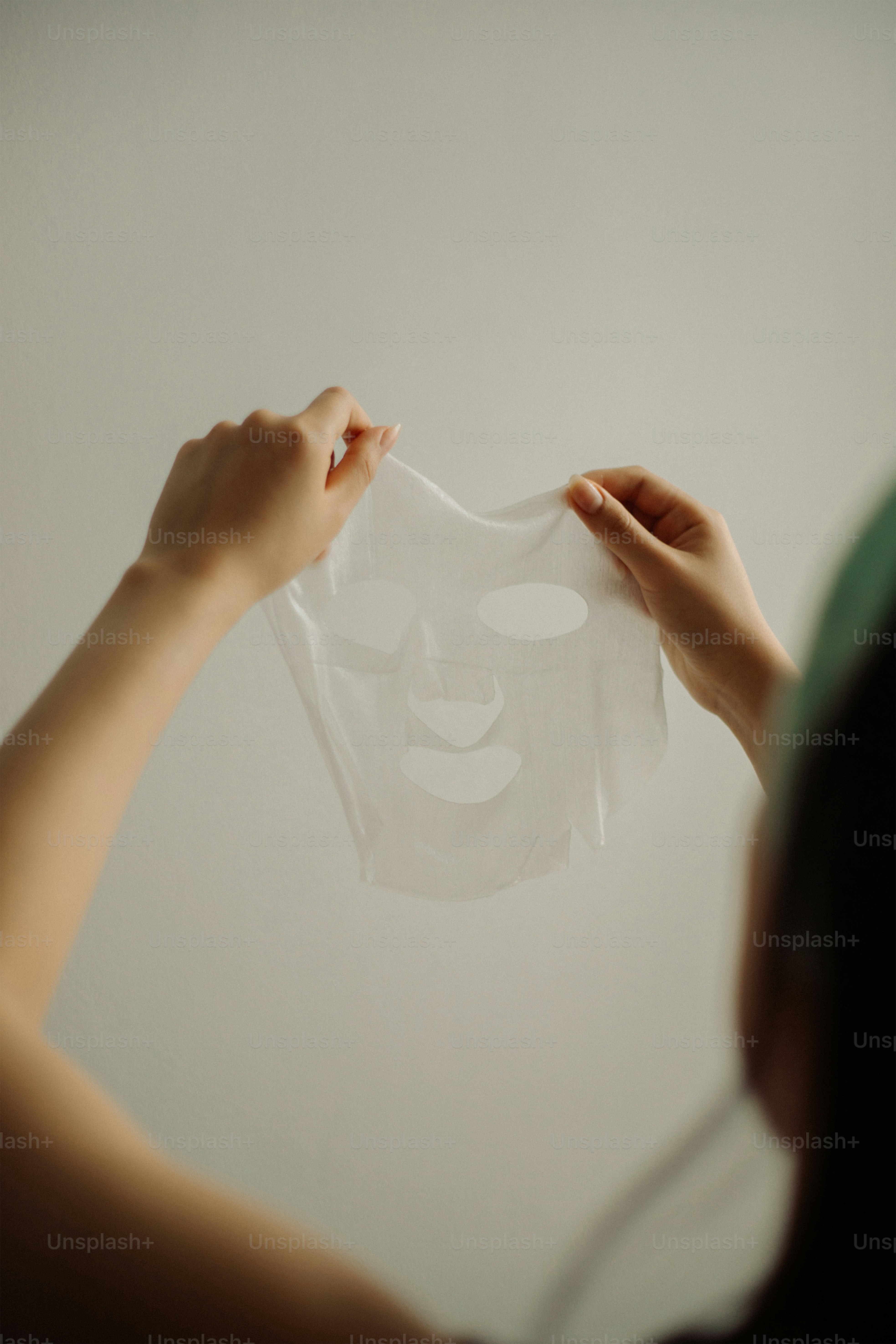 Holding a sheet mask for skincare.